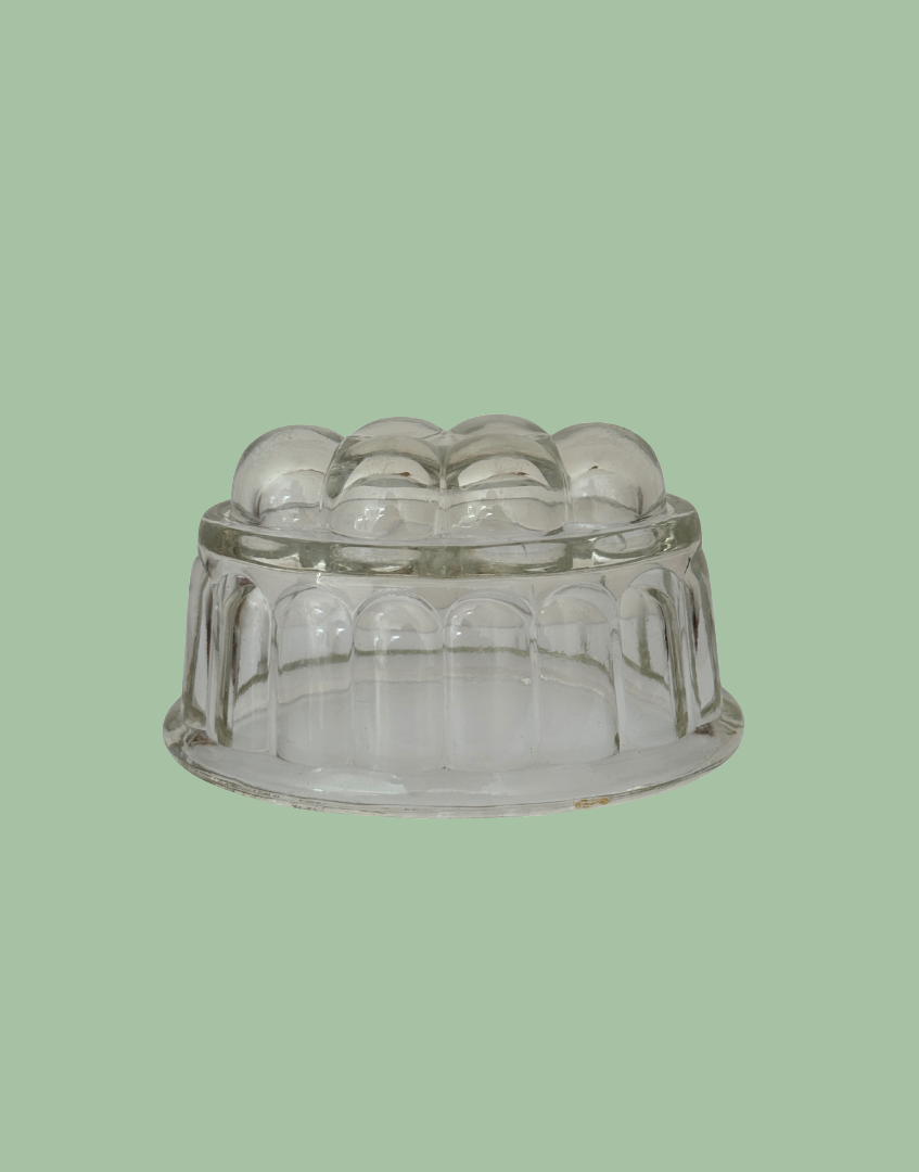 Side view of clear glass vintage jelly mould
