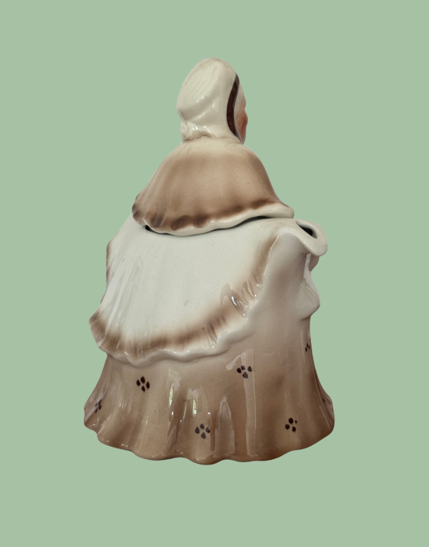 Side back view of vintage brown Staffordshire pottery Little Old Lady teapot showing umbrella spout and curved handle detail