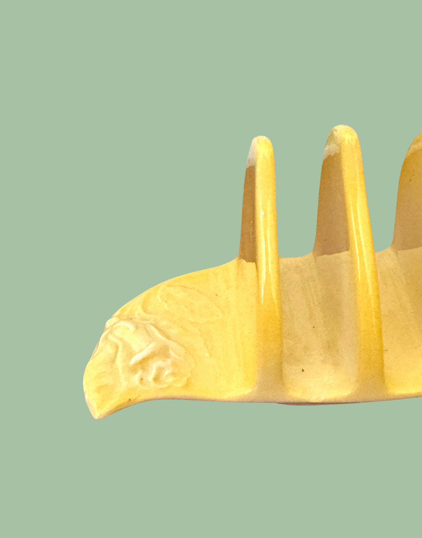 Close up of pretty floral on end of yellow vintage ceramic toast rack
