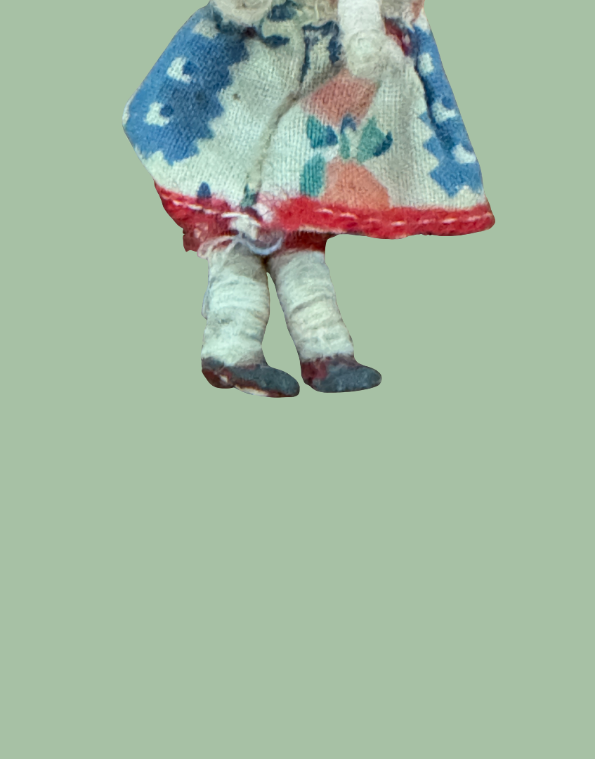 Close up of doll collectable with a colourful dress on a polka dot background