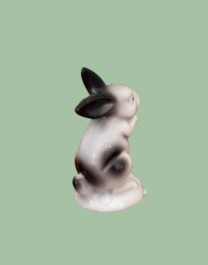 Side view of miniature black and white ceramic rabbit figurime