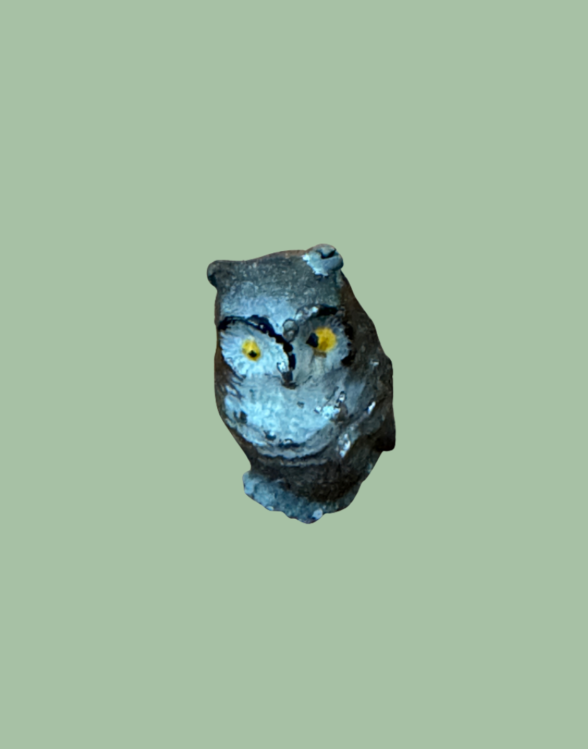 small vintage owl figurine with expressive yellow eyes