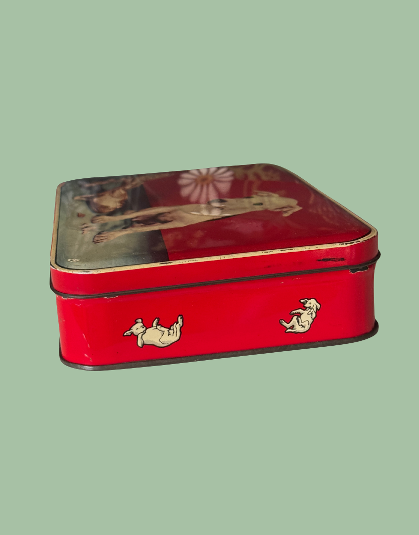 Side view of red vintage tin with dog detaisl to side