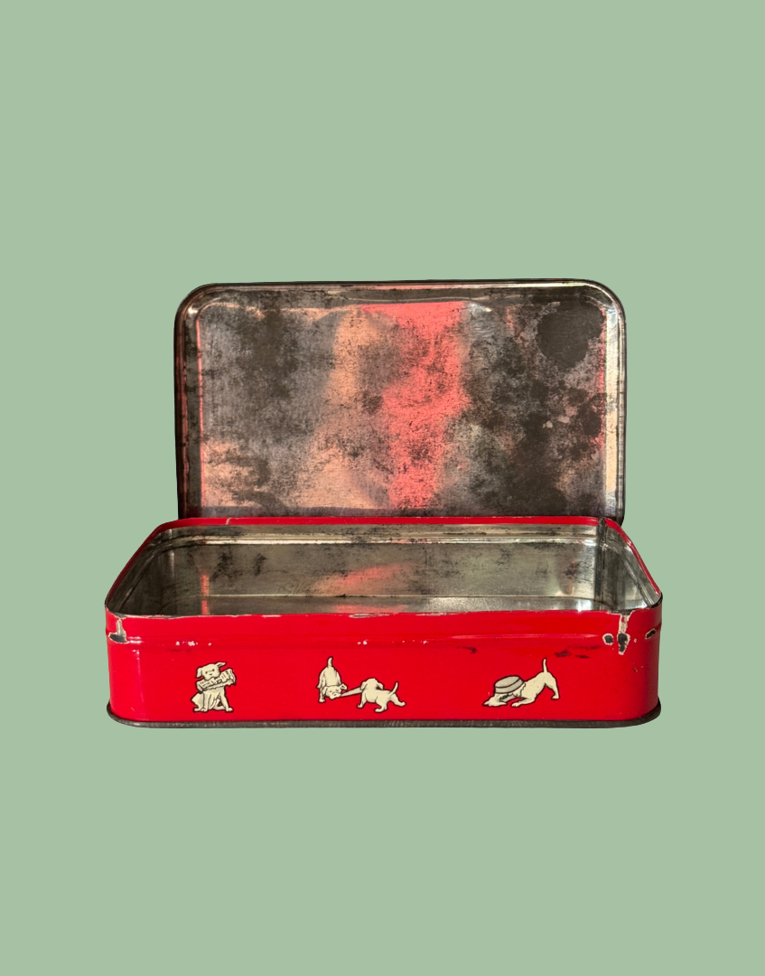 Red metal collectable tin with lid open and charming dog illustrations