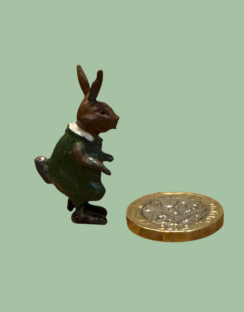 Tiny rabbit lead toy next to one pound coin