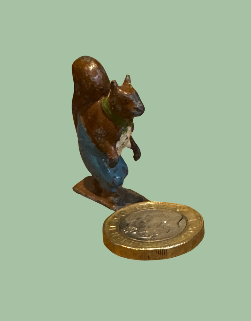 ‘Nutty Squirrel’ miniature lead toy next to one pound coin for scale