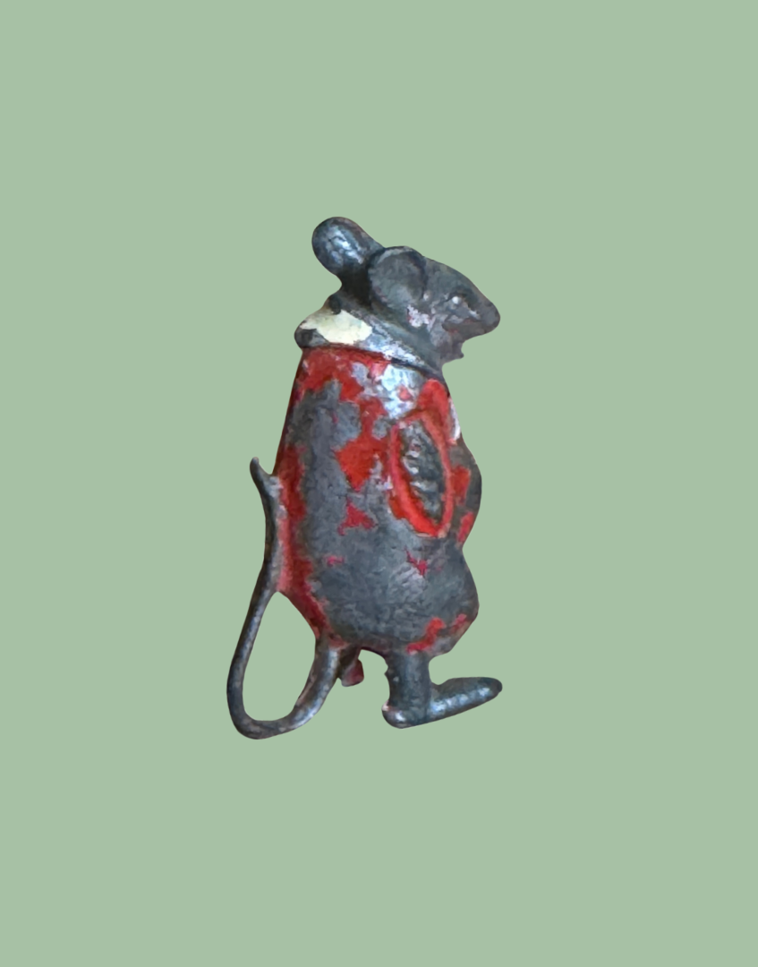 Miniature collectbale lead monkey figurine next to a pound coin