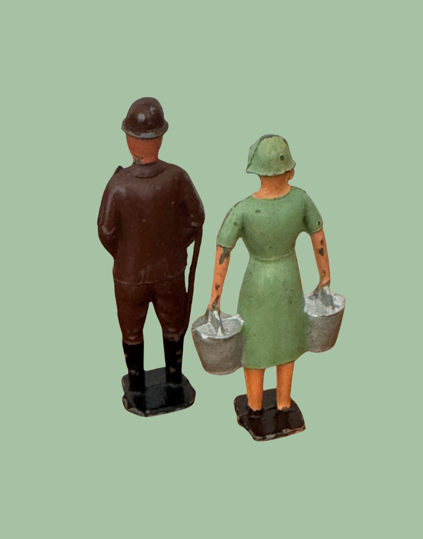 a pair of lead cast figurines from behind from britains farm collections