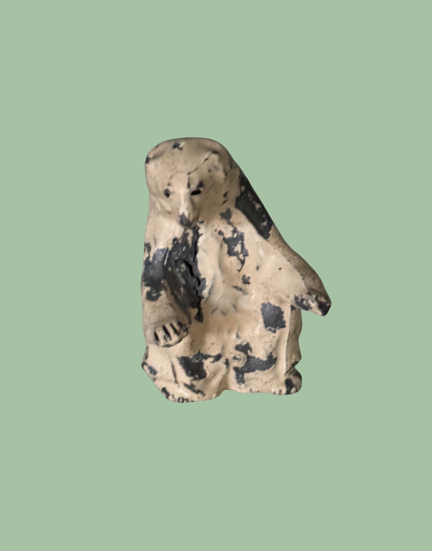 Small vintage figurine of a white polar bear on a polka dot background