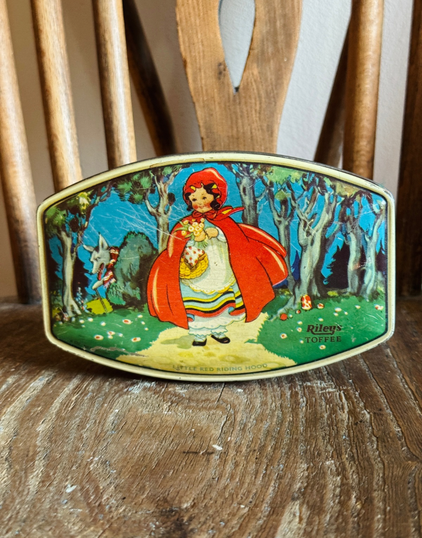 vintage Riley’s toffee tin with Little Red Riding Hood illustration styled on an antique wood chair.