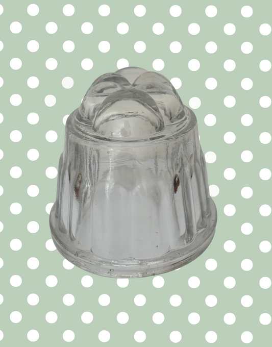 Clear glass jelly mold on a polka dot background