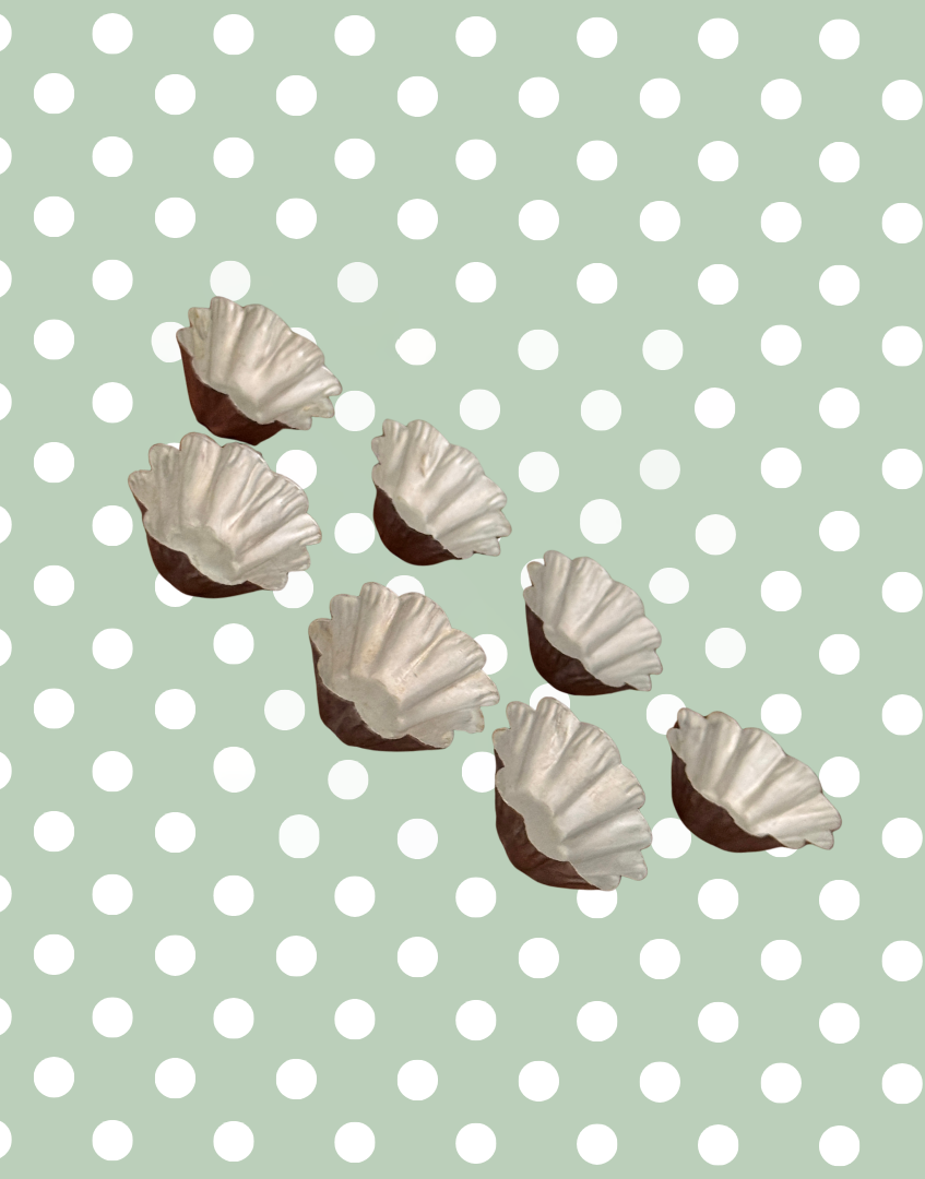 Seven vintage petit four moulds arranged in rows showing matching fluted design and aged metal character