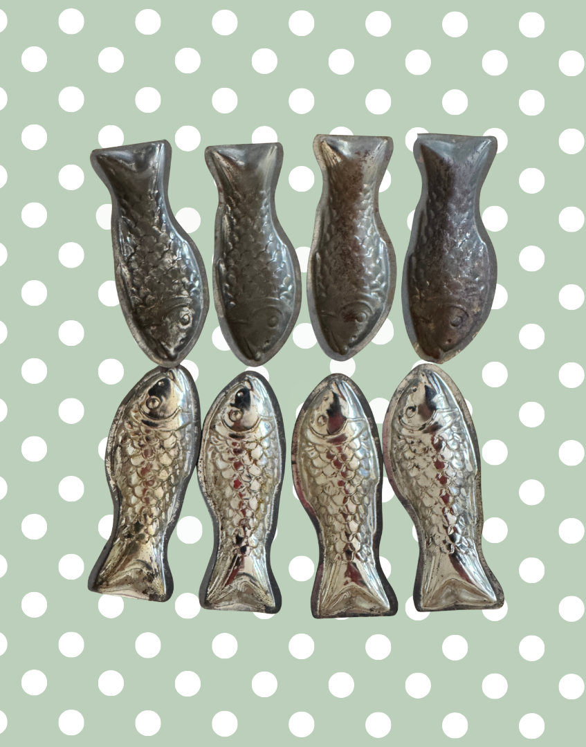 Reverse view of eight vintage fish shaped aluminium moulds showing original flat tail extensions used for holding in production trays