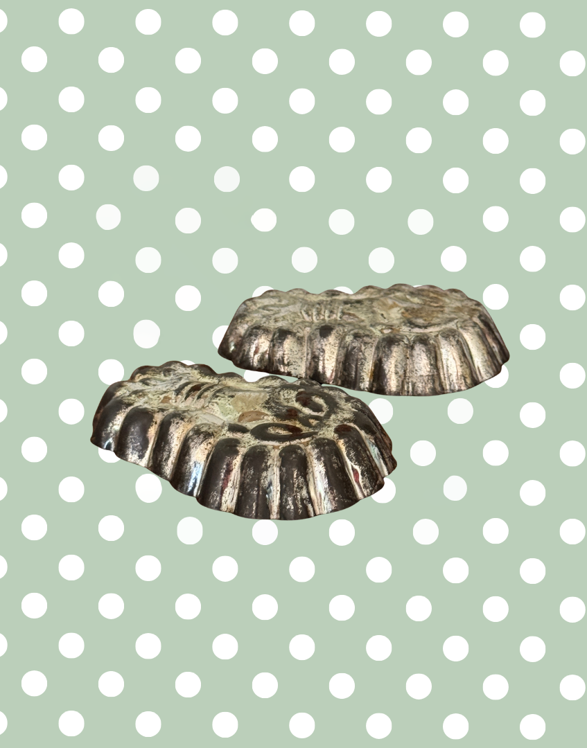 Side view of matching vintage lobster shaped tinplate mould pair showing detailed outline and decorative design