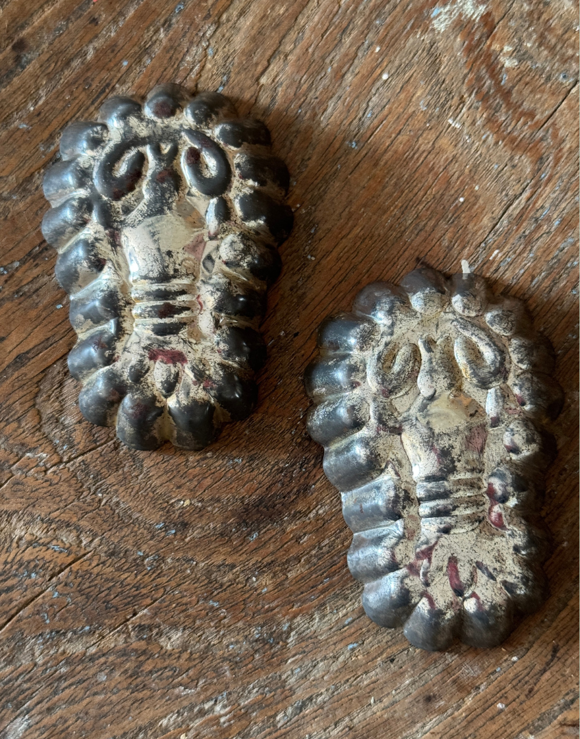 Vintage lobster tinplate mould pair displayed on an antique wood surface highlighting rustic kitchenalia charm and patina