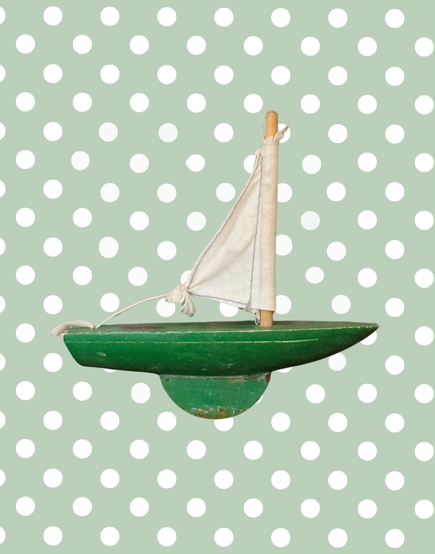Side view of vintage Star Yachts No. 0 pond yacht showing its apple green wooden hull, sail and weighted keel.