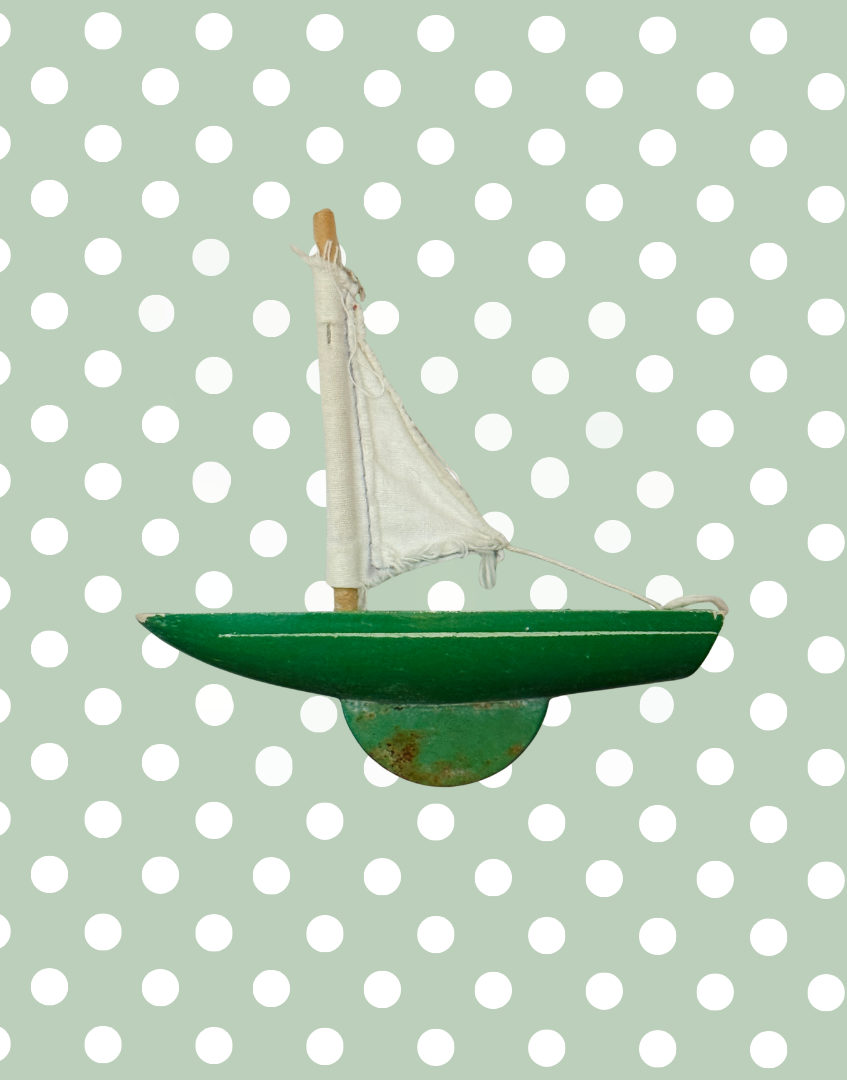 Alternate side view of the miniature green Star Yachts pond yacht with white sail and traditional wooden construction.