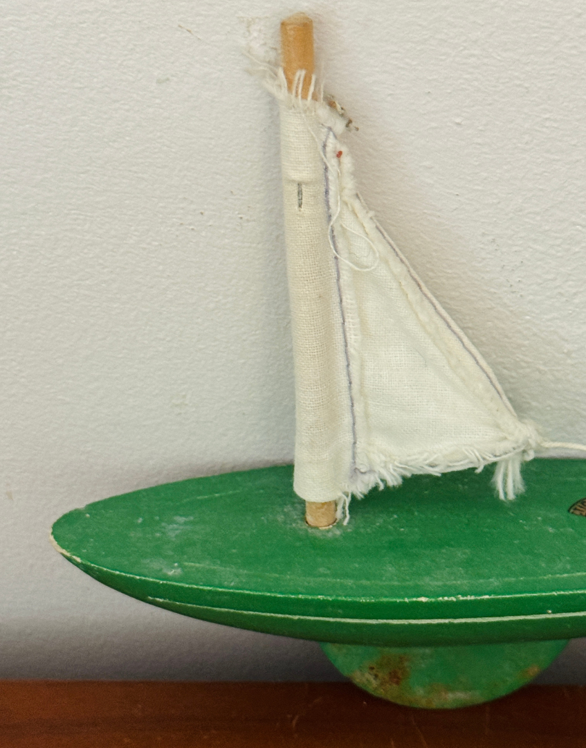 Close up of the original white sail showing its aged fabric, stitching and signs of vintage wear.