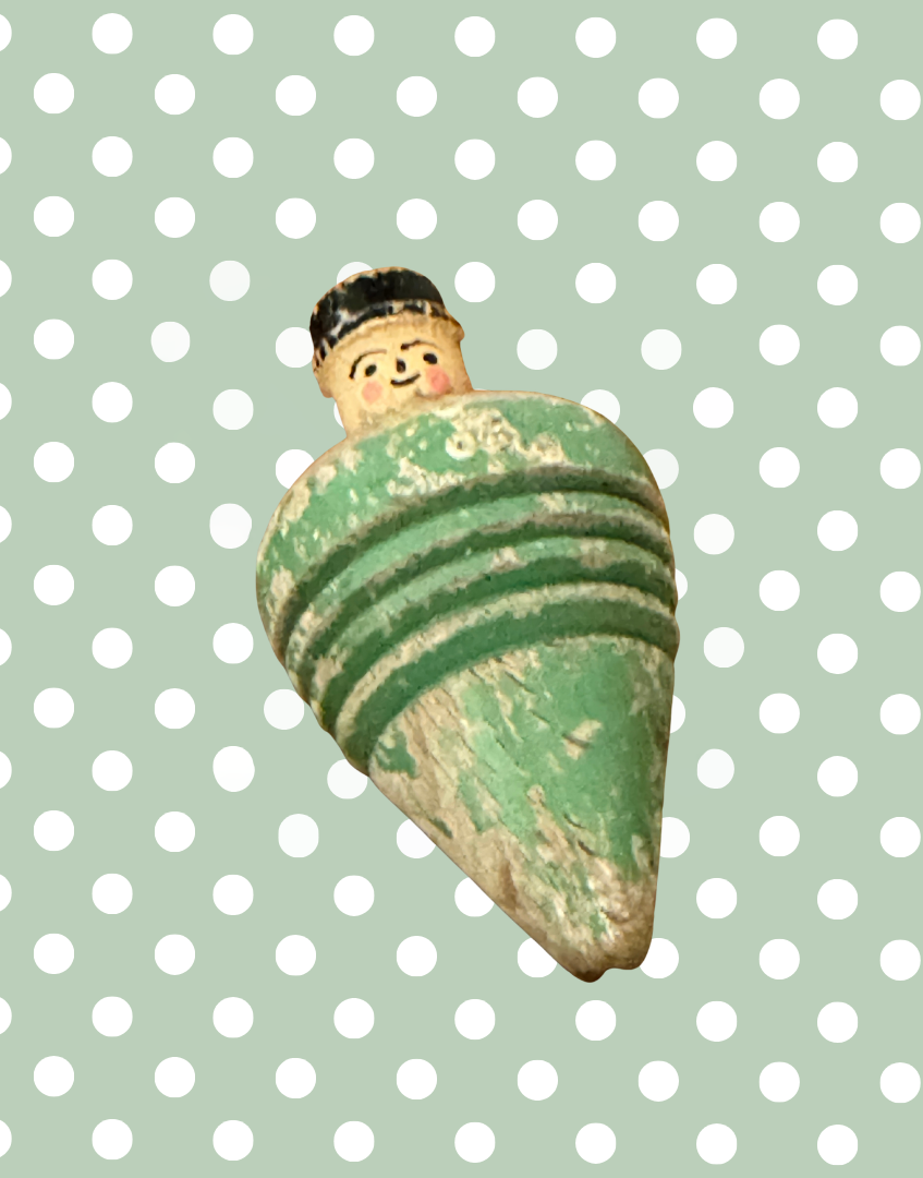 Overview of the antique wooden spinning top featuring a three dimensional hand carved gentleman with painted details.