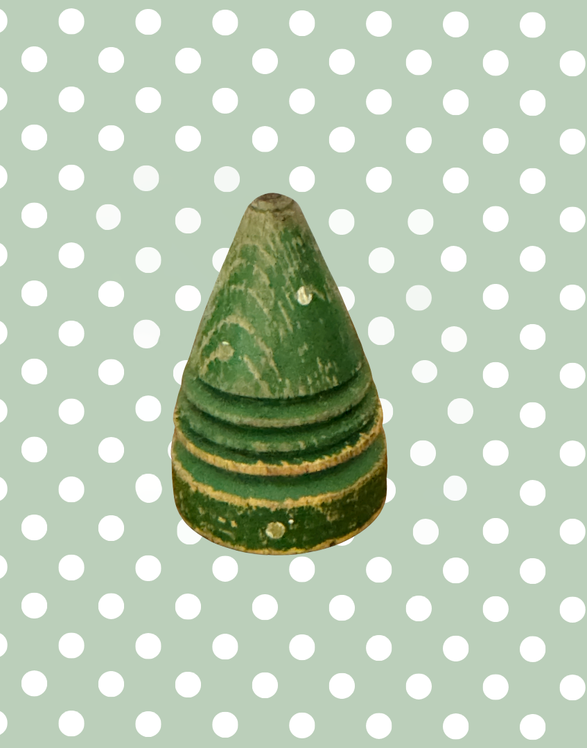 Close front view of the antique polka dot spinning top showing its painted wooden surface and traditional form.