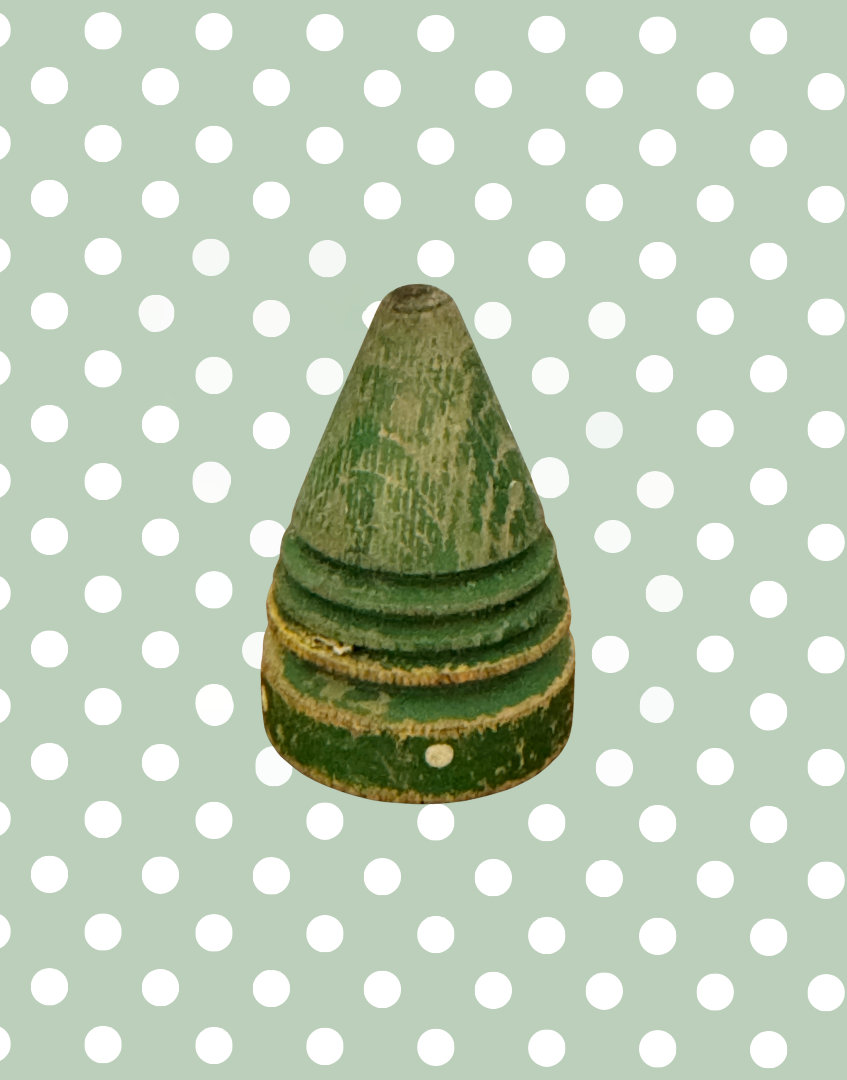 Antique painted wooden spinning top showing its original polka dot decoration and aged character.