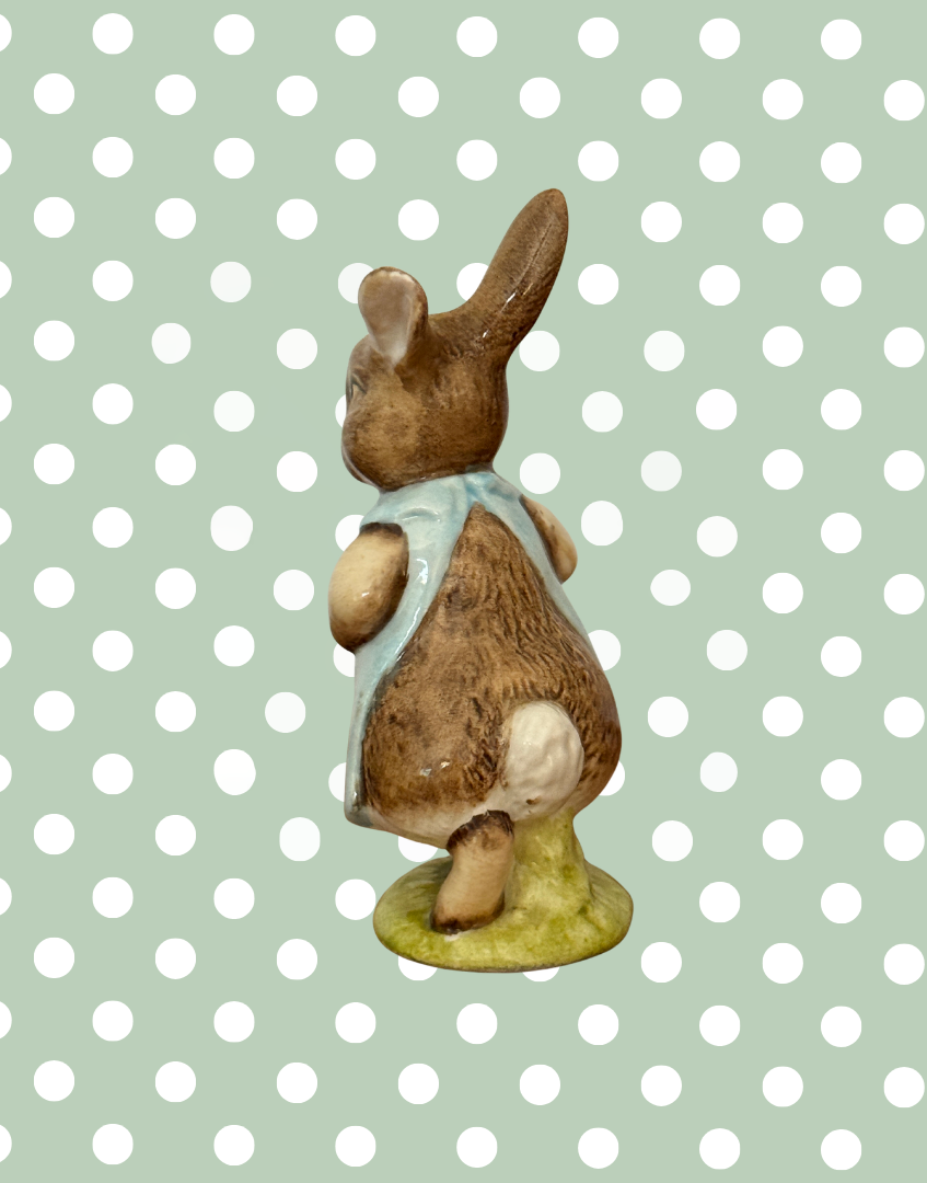 Left rear view of vintage Beswick Mrs Flopsy Bunny showing her white tail and green base.