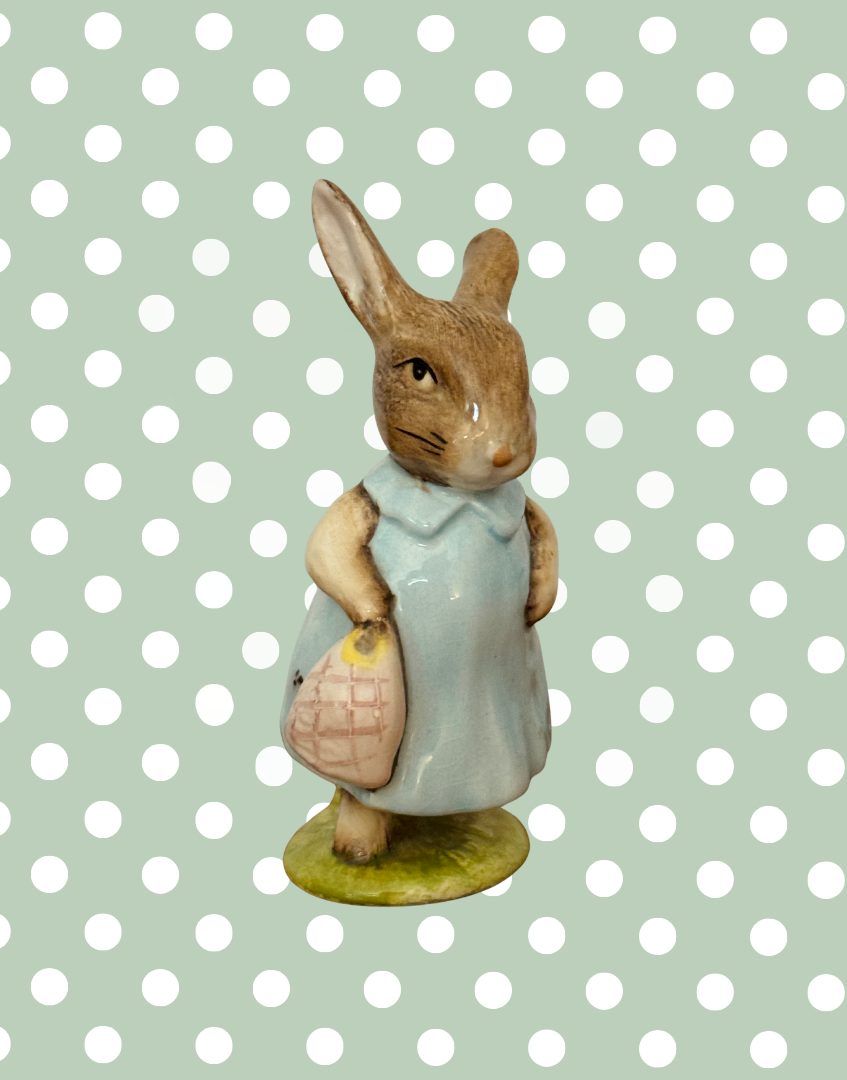 Front side view of Beswick Mrs Flopsy Bunny showing her blue clothing and small handbag.