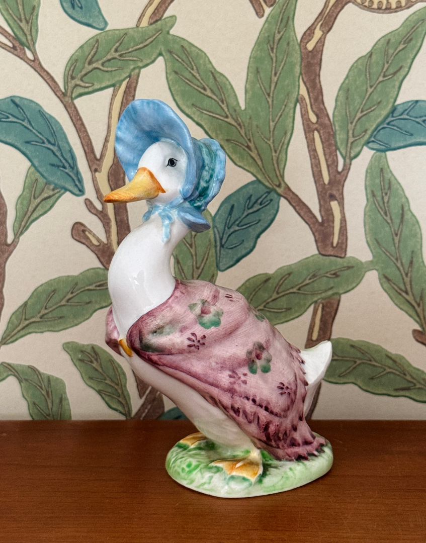 Vintage Beswick Jemima Puddle Duck figurine styled on a wooden shelf with William Morris wallpaper