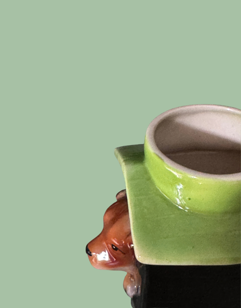 Close-up of the green egg holder and roof showing a small raised glaze point on the Tony Wood kennel egg cup.