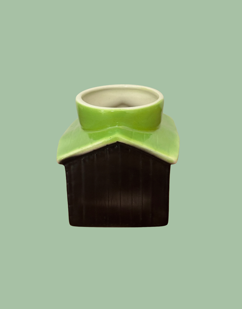 Back of Tony Wood kennel egg cup showing vertical wooden-board detailing beneath the green roof and cream-lined egg holder.