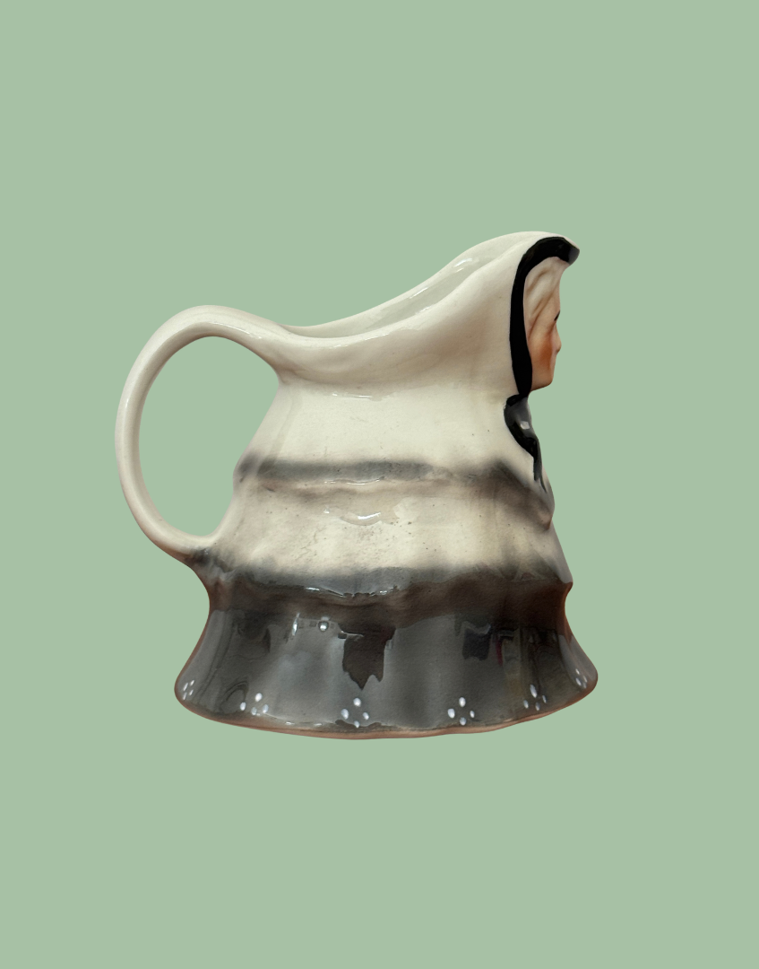 Side profile of Tony Wood Little Old Lady milk jug showing the curved handle, pouring lip and moulded clothing.