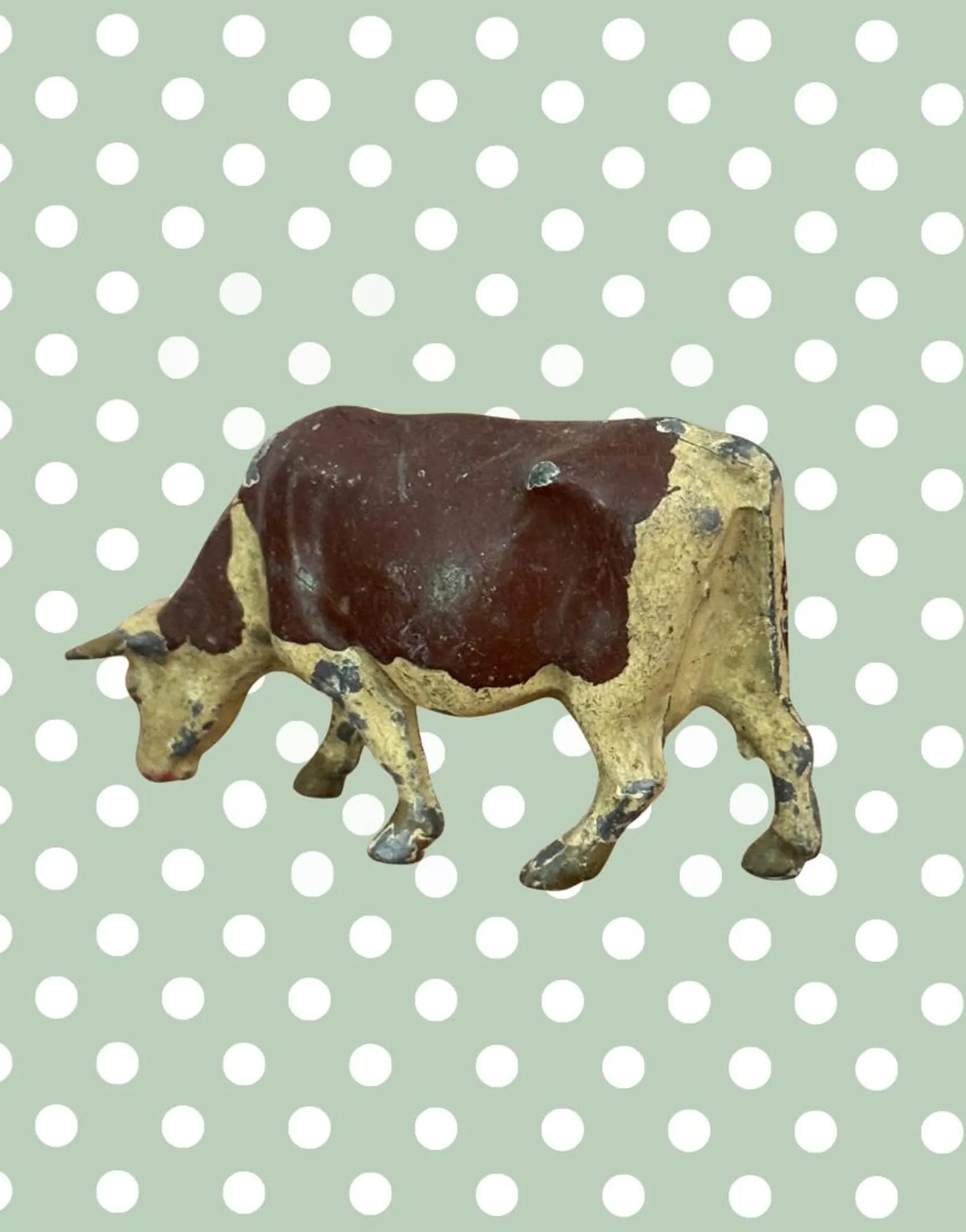 Vintage toy cow figure on a polka dot background