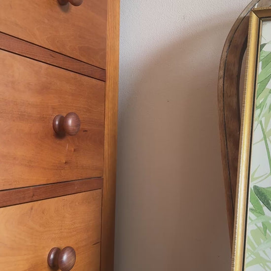 Close up of vintage gilt framed green and white palm botanical print plaed on antique wood chair.