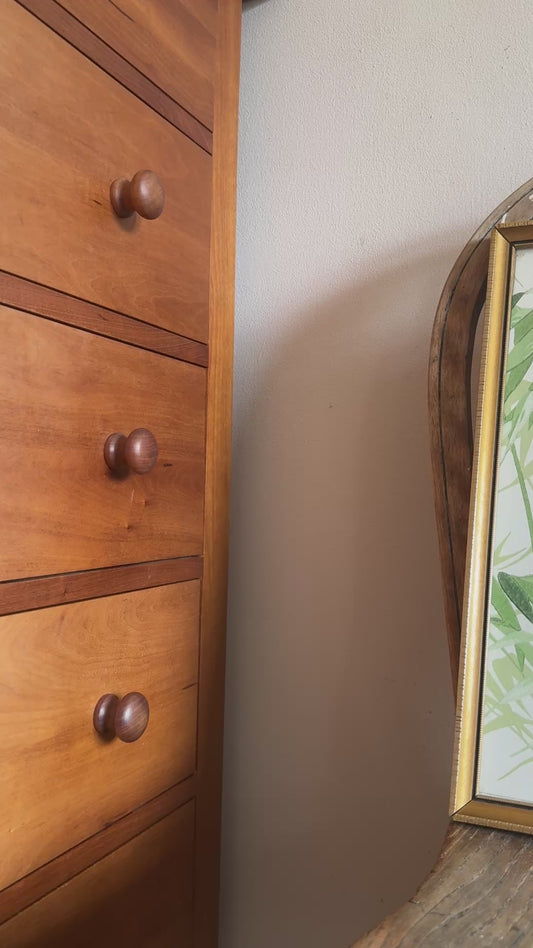 Close up of vintage gilt framed green and white palm botanical print plaed on antique wood chair.