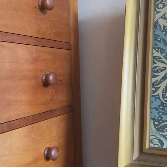 Vintage framed William Morris print styled on an antique wooden chair in a rustic cottage setting