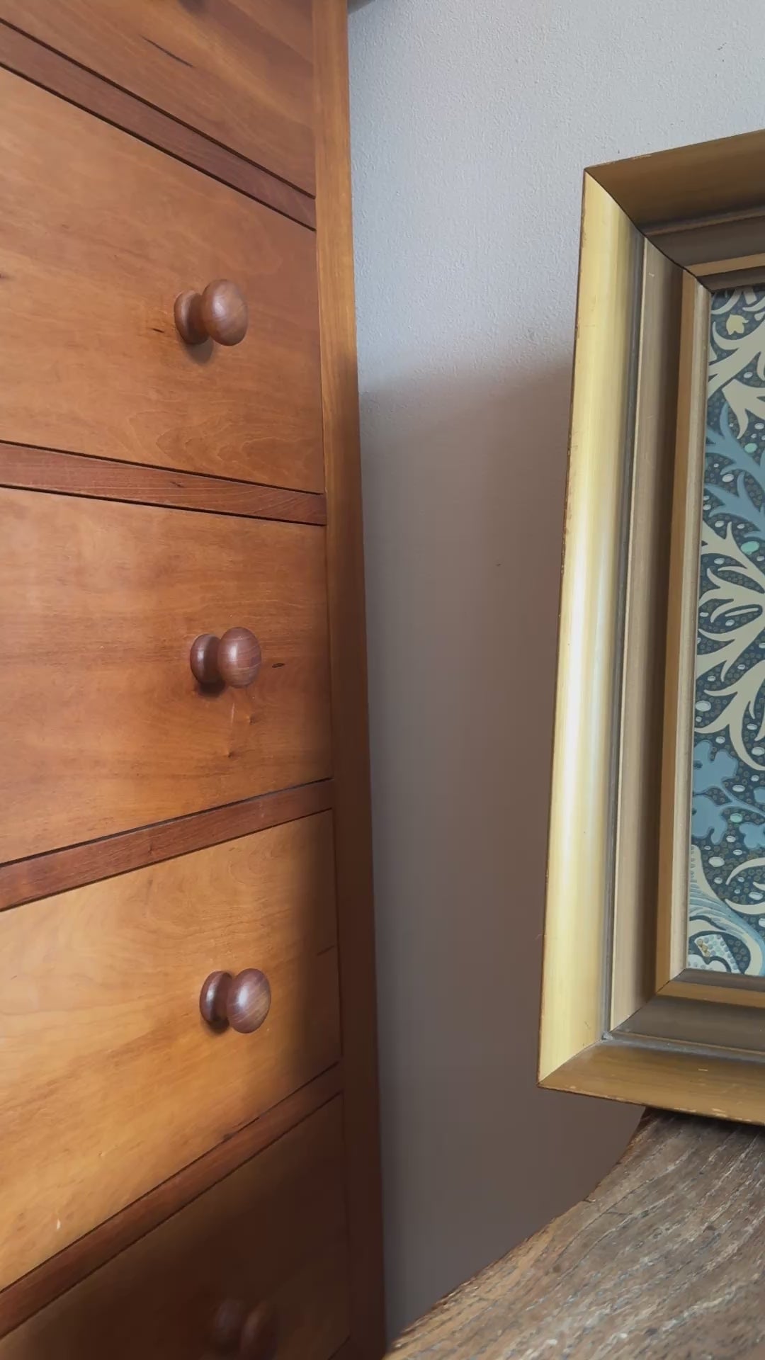 Vintage framed William Morris print styled on an antique wooden chair in a rustic cottage setting