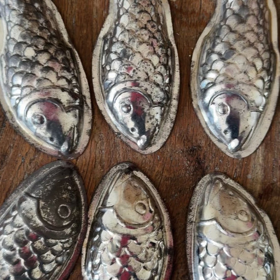 Eight vintage aluminium fish moulds displayed together showing their unusual decorative shape and aged patina