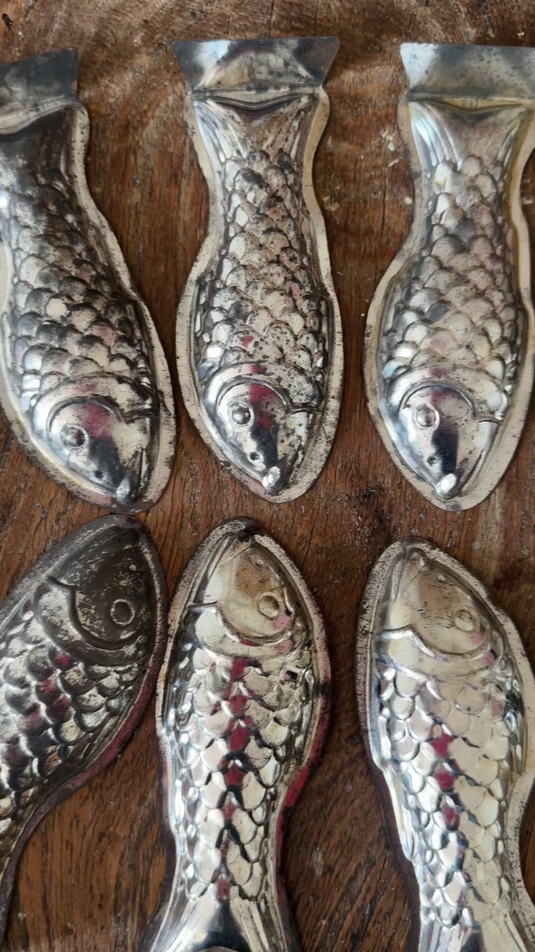 Eight vintage aluminium fish moulds displayed together showing their unusual decorative shape and aged patina