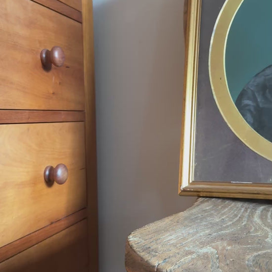 Antique gold and brown framed of a portrait of woman. The frame is positioned on an antique wooden chair.