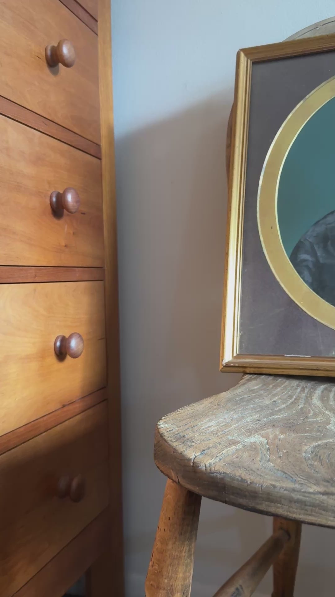 Antique gold and brown framed of a portrait of woman. The frame is positioned on an antique wooden chair.