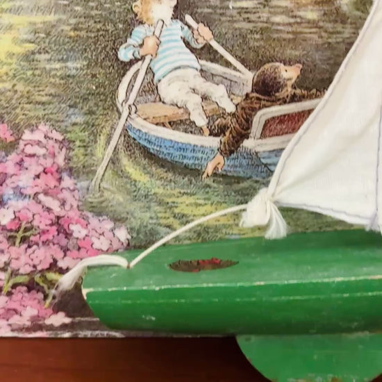 Small vintage Star Yachts green pond yacht with removable white sail and aged original wooden hull.